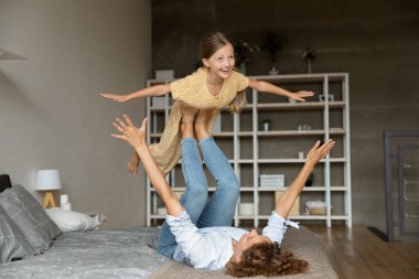 Neşeli küçük kız annesinin yardımıyla uçuyor.