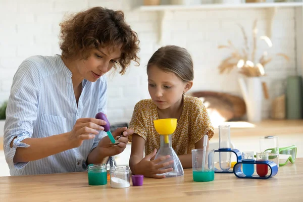 Küçük kız ablasını çocuklar için kimya seti kullanarak izliyor. — Stok fotoğraf