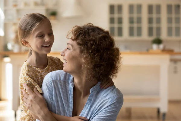 Heyecanlı şefkatli anne, küçük sevgi dolu kızının samimi kucaklamalarının tadını çıkar.