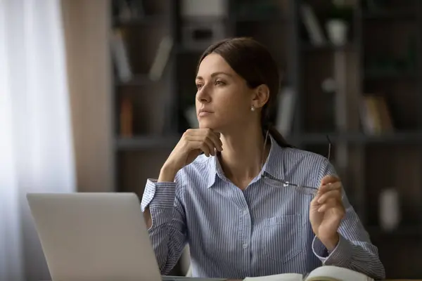 Pensiv kvinnlig anställd ser på distans tänkande — Stockfoto