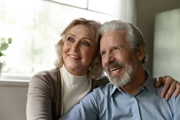 Pensivo casal de família reformado maduro olhando para longe e sorrindo — Fotografia de Stock