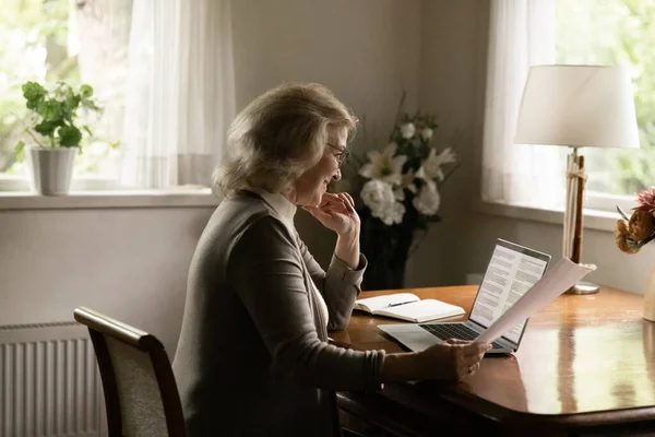 Счастливый пенсионного среднего возраста женщина проверки бумаги, финансовый документ — стоковое фото