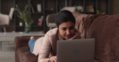 Evde bilgisayar kullanan rahat bir Hintli kadın..