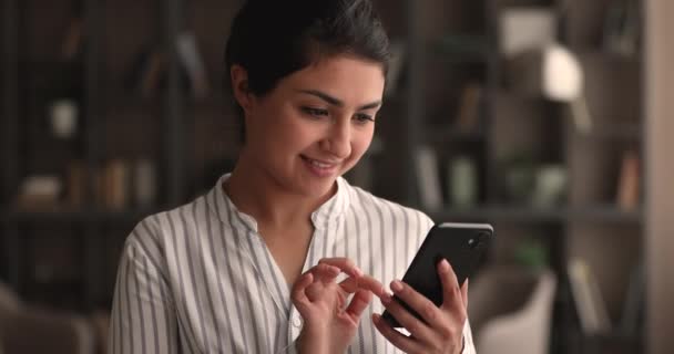 Mosolygó fiatal indiai nő segítségével mobiltelefon alkalmazás. — Stock videók