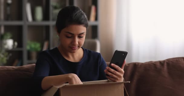 Leende tusenårig indian kvinna kontrollera ordning i mobilappen. — Stockvideo