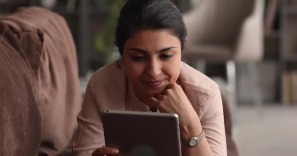 デジタルコンピュータタブレットを使用して夢のような若い幸せなインド人女性. — ストック動画