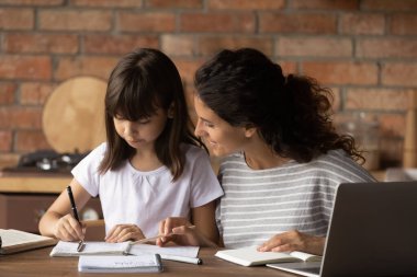 Genç Latin anne okul hazırlıklarına yardım ediyor.