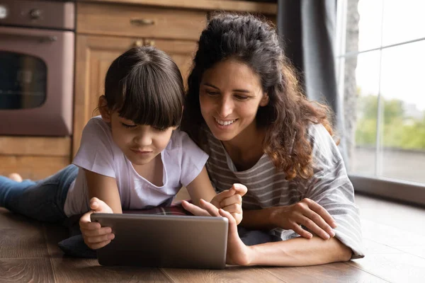 Mutlu genç Latin anne ve kızı tablet kullanıyor. — Stok fotoğraf