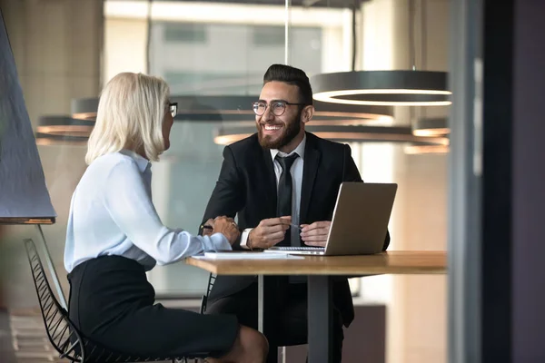 Europese Arabische zakenpartners zitten aan de balie tijdens vergadering — Stockfoto