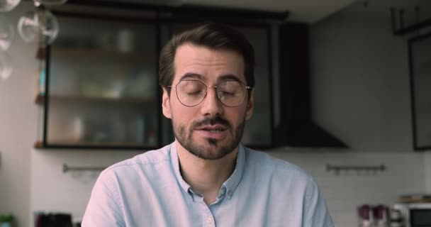 Jóképű fiatalember szemüvegben élvezi a webkamerás beszélgetést.. — Stock videók