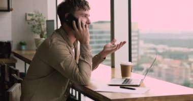 Genç odaklı işadamı ortaklarıyla cep telefonu görüşmesi yapıyor.