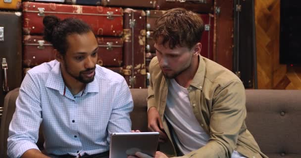 Happy two young multiracial male business partners discussing online data. — Stock Video