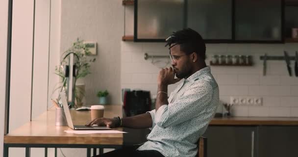 Pensiv ung afrikansk amerikansk affärsman som arbetar med dator. — Stockvideo