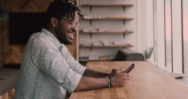 Duygusal milenyum melezi Afrikalı hippi adam iyi haberler okuyor..