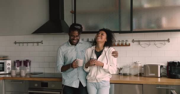Feliz jovem afro afetuoso família casal beber café na cozinha. — Vídeo de Stock