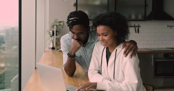 Glad ung bindning afrikansk amerikansk familj par med hjälp av dator. — Stockvideo