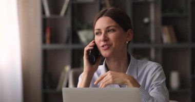 Cep telefonu sohbeti yapan gülümseyen genç iş kadınından dikkati dağılmış.