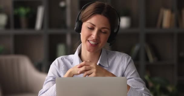 Joven amigable feliz 35s mujer de negocios en auriculares celebración de videollamada. — Vídeos de Stock