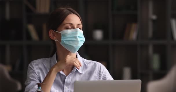 Pensativo jovem empregada feminina em facemask trabalhando no computador. — Vídeo de Stock