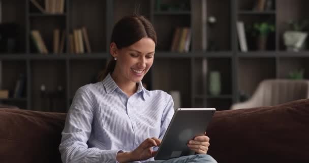 Boldog fiatal 35-ös nő néz vicces videó tabletta. — Stock videók