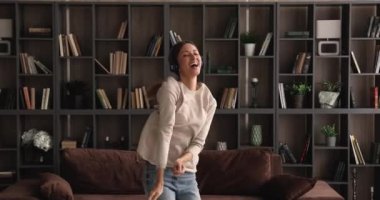 Enerjik, gülen, 30 'lu yaşlarda, evinde dans eden genç bir kadın..