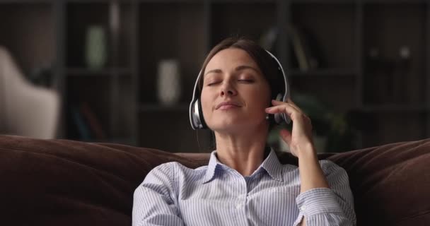 Νεαρή ευτυχισμένη γυναίκα ακούγοντας χαλαρωτική μουσική στα ακουστικά. — Αρχείο Βίντεο