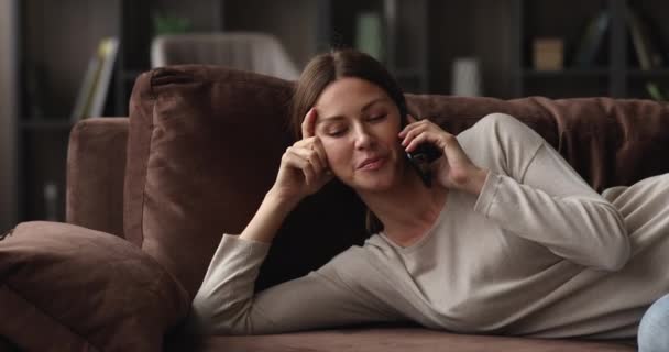 İçten gülümseyen genç bir kadın cep telefonuyla konuşuyor.. — Stok video