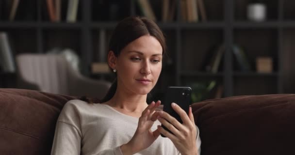 Sonriendo hermosa mujer de 30 años utilizando la aplicación de teléfono inteligente. — Vídeos de Stock