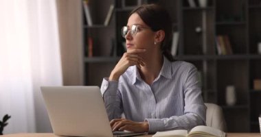 Gözlüklü genç kadın bilgisayarla çalışıyor..