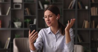 Telsiz kulaklıklı, cep telefonlu mutlu genç iş kadını..