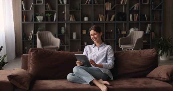 Χαλαρωμένη νεαρή γυναίκα που χρησιμοποιεί ψηφιακό tablet υπολογιστή. — Αρχείο Βίντεο