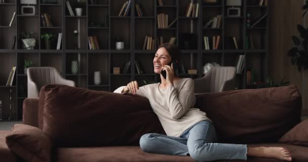 Glad ung avslappnad kvinna pratar på mobiltelefon med vänner. — Stockvideo