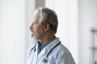 Düşünceli olgun erkek doktor, mesafeli düşün.