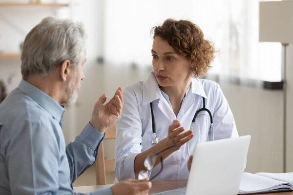 Female doctor consult mature male patient in clinic