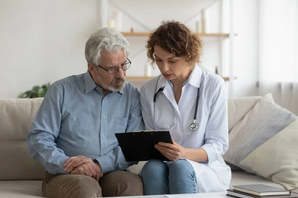 Female nurse consult mature man patient at home — Stock Photo, Image