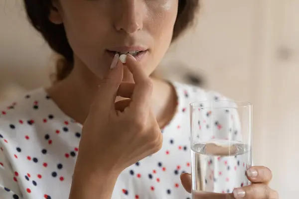 Jongedame hold glas water voor te bereiden om pil slikken — Stockfoto