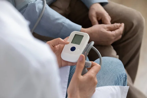 Close up of female nurse measure heartbeat of mature patient — Stock Photo, Image