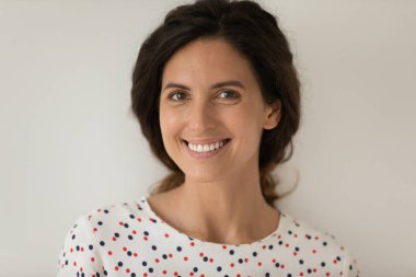 Güzel saçlı, gülümseyen genç bayanın yakın plan portresi.