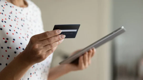 Les mains féminines détiennent tablette carte de crédit faire des achats sur Internet — Photo