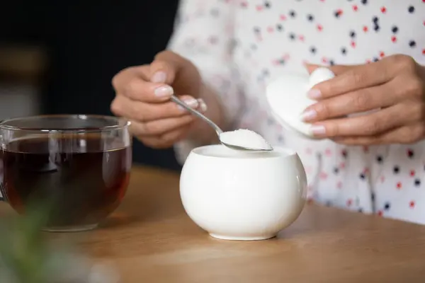 Mladá dáma vaření čaj přidat lžička cukru do šálku — Stock fotografie