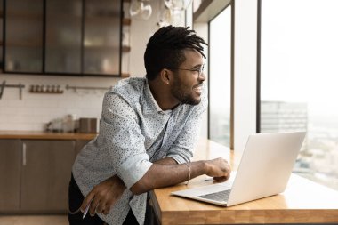 Gülümseyen Afrikalı Afrikalı Amerikalı adamın laptoptan dikkati dağıldı.