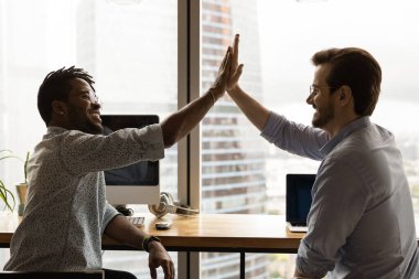 Yan manzara, çeşitli meslektaşların coşkuyla beşlik çakması ve başarıyı kutlaması.