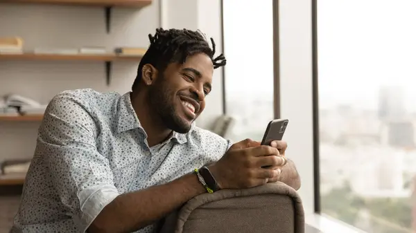 Close up smiling African American man using phone, chatting — Stock Photo, Image