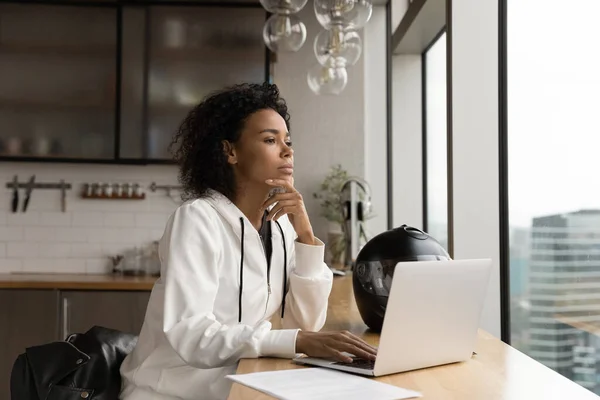 Close up thoughtful African American businesswoman looking out window