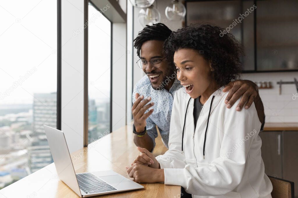 Close up overjoyed surprised African American couple reading good news