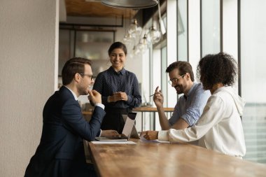 Mutlu çeşitli meslektaşlar şirket toplantısında eğleniyor, gülüyorlar.