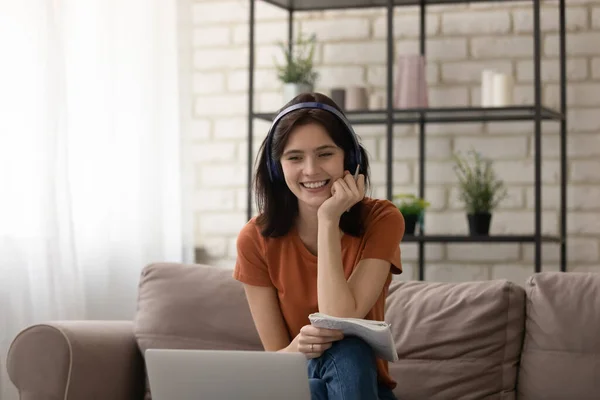 ヘッドフォンで笑顔若い女性はノートパソコンで先生に耳を傾ける — ストック写真