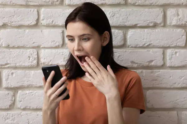Šokovaný žena teenager při pohledu na obrazovce telefonu čtení ohromující novinky — Stock fotografie