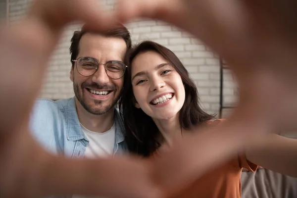 Pareja familiar romántica haciendo corazón de dedos mirando a la cámara — Foto de Stock