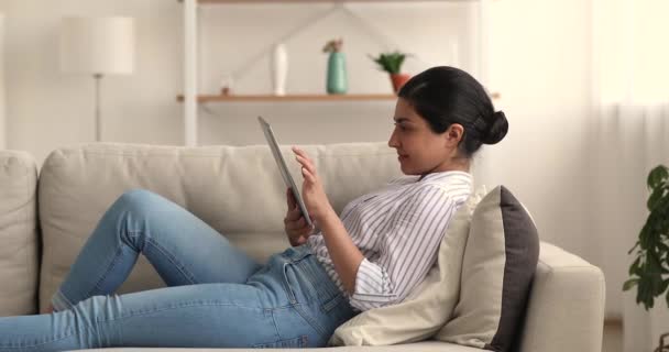 Relaxé jeune femme biraciale indienne en utilisant une tablette numérique. — Video